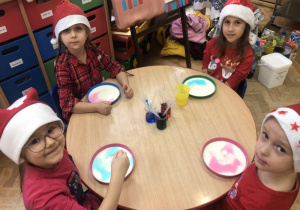 dzieci robią doświadczenia z mlekiem i barwnikami przy stolikach